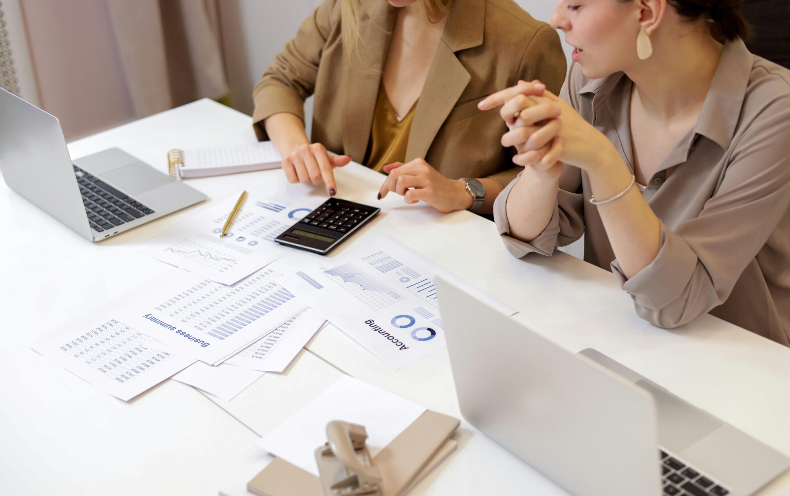 Two professionals collaborating on financial documents in a modern office setting.